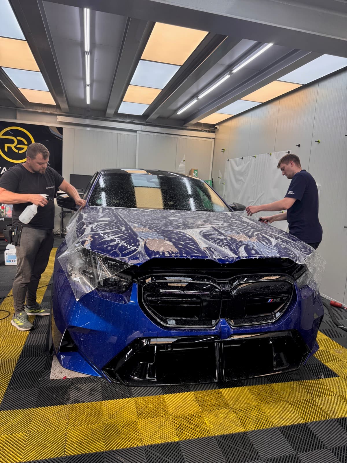 Blauer BMW M5 während der Lackschutzfolierung