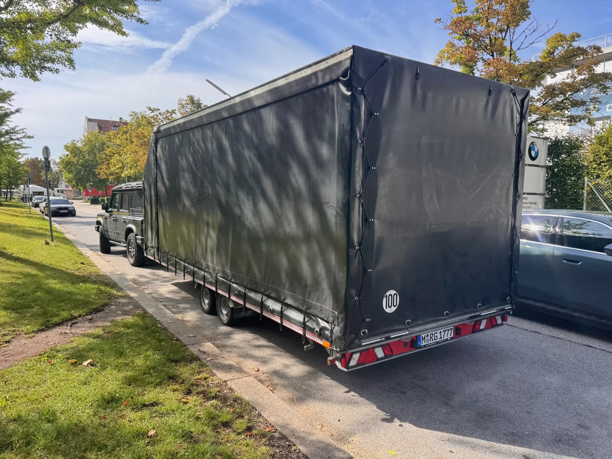 Geschlossener Anhänger von Royal Glanz vor einem BMW-Händler in München zur Neuwagen-Abholung