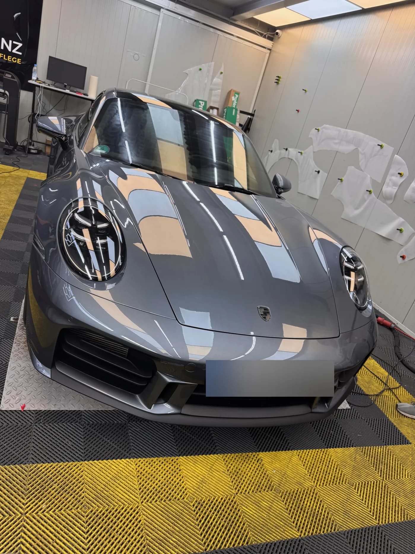 Porsche 911 in der Royal Glanz Werkstatt München, im Hintergrund PPF-Schablonen an der Wand